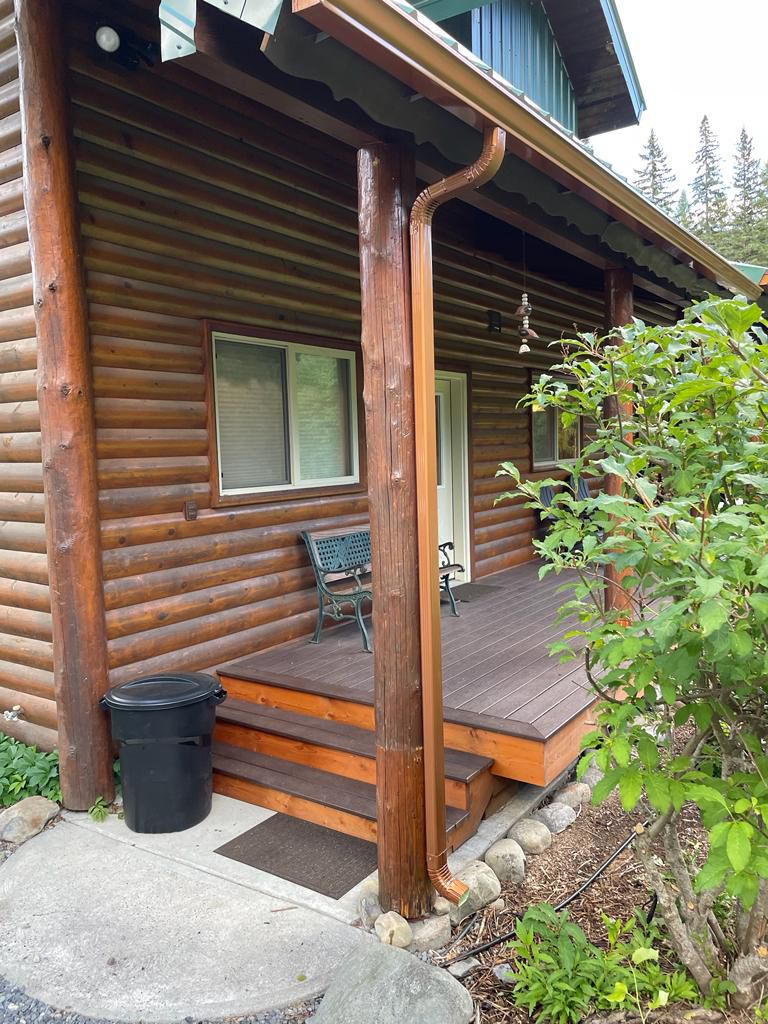 Log cabin with porch and gutters